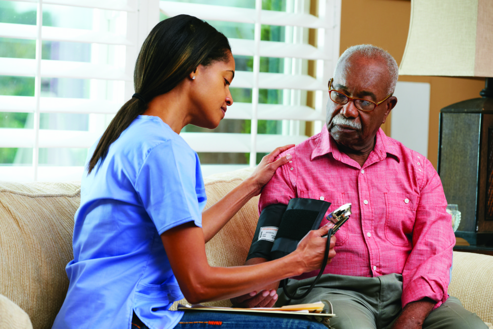 Nurse Visiting Senior Male Patient At Home